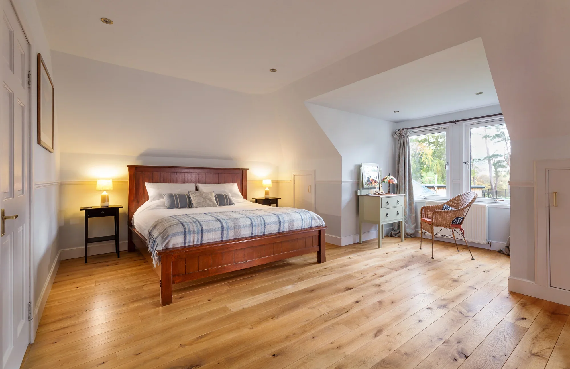 Spacious King Room at WEE WiLDS — king bed with white linen, solid oak floor, two windows overlooking the garden